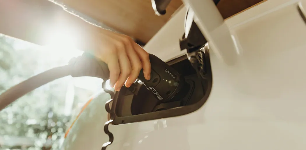 Nærbillede af et ladekabel, der er forbundet til en elbil.